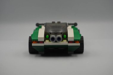 Yeşil arabanın arkası Lego DC karakterinin oyuncağına tuğla örüyor. Bilmececi 'nin beyaz geçmişi var.
