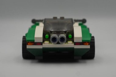 Yeşil arabanın arkası Lego DC karakterinin oyuncağına tuğla örüyor. Bilmececi 'nin beyaz geçmişi var.