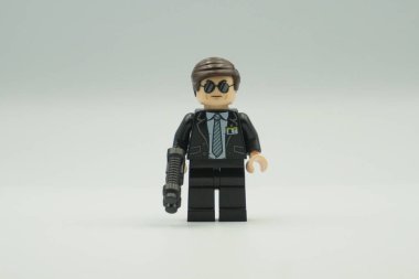 Beyaz arka planda takım elbiseli ve güneş gözlüklü Ajan Coulson.