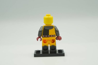Beyaz arka planda sarı ve gri kostümlü oyuncak tuğlalardan Lego Turnuvası Şövalyesi mini figürü.