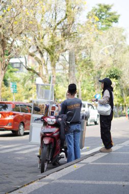 Motorlu sokak yemekleri (cilok) satıcıları öğleden sonra yol kenarında satış yapıyorlar