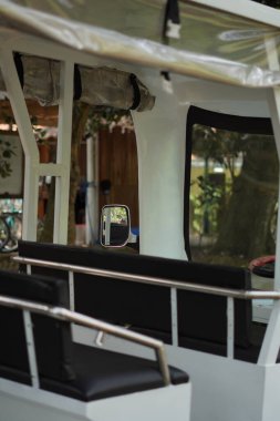 Beyaz bir golf arabası yolun kenarında turistik bir bölgede park halinde.