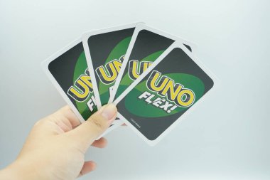 A hand holding four cards from UNO Flex (board game) on a white background. clipart