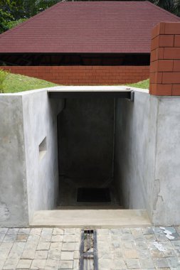 Umumi bir yerde küçük, karanlık, hafif eğimli bir oda.