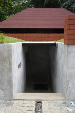 Umumi bir yerde küçük, karanlık, hafif eğimli bir oda.