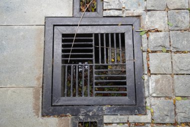 Demirden yapılmış bir kapakla kamusal alanda drenaj.