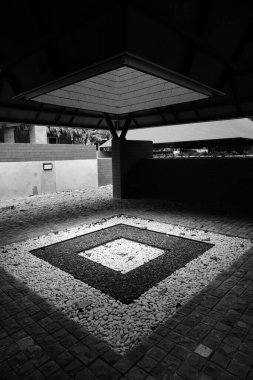 Semi-outdoor garden in a roofed area in the middle there is a box area that is exposed to sunlight coming in from the open roof clipart