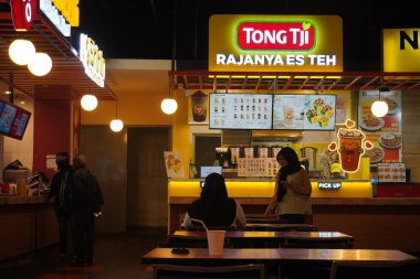 Tong Tjie 'nin standı alışveriş merkezinde işlenmiş çay ve atıştırmalık satıyor.