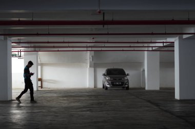 Arabaların park edildiği bir binanın bodrumu boş ve sadece bir sedan ile dolu.