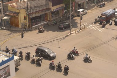 Arabalar ve motorsikletler Endonezya 'daki eski binalarla ana kavşaklardan geçerek retro titreşimli