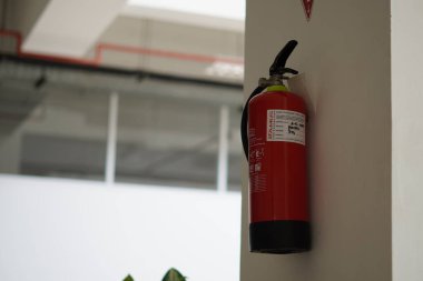 Minimalist bir binanın duvarına bağlı bir yangın söndürücü.