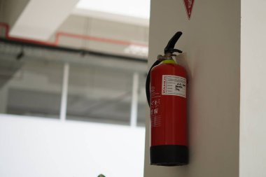 Minimalist bir binanın duvarına bağlı bir yangın söndürücü.