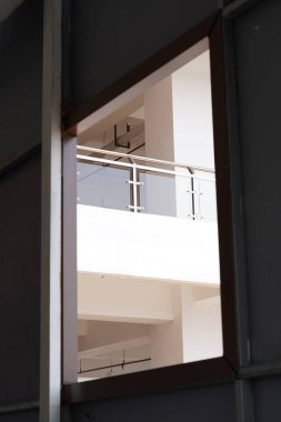 The balcony of a minimalist white multi-storey building seen from the bottom window clipart