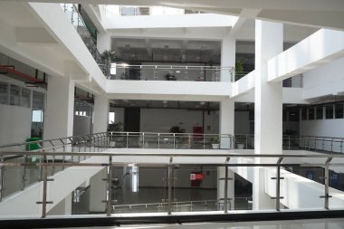 Sessiz minimalist, beyaz, çok katlı bina gündüz gözlüklü çatıdan parlak bir ışık alıyor.