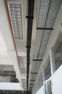 Terk edilmiş bir binanın tepesine kadar uzanan kırmızı borular ve öncü ışıklar.