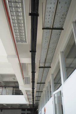 Terk edilmiş bir binanın tepesine kadar uzanan kırmızı borular ve öncü ışıklar.