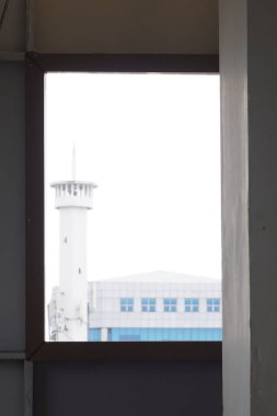 Peeking at a tall building from behind a hole in the window of a multi-storey building clipart