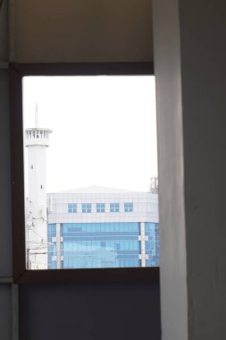 Çok katlı bir binanın penceresindeki bir delikten yüksek bir binaya gizlice bakmak.