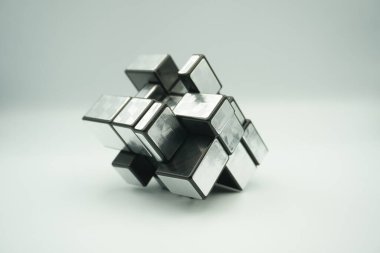 A 3x3 silver rubik's mirror cube toy that is scrambled on a white background clipart