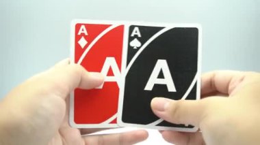 Beyaz arkaplanlı bir iskambil destesinde her türlü ası gösteren bir el.