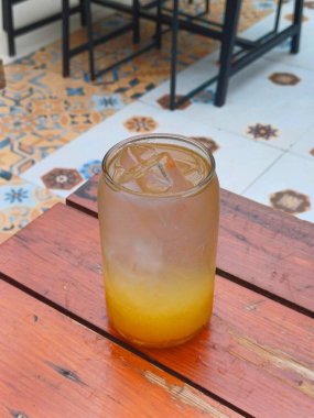 Buzlu portakal suyunu berrak bir bardakta tazeliyorum.