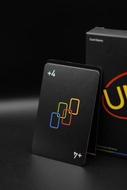 +Siyah arkaplanı olan siyah bir Uno kart kutusunun üzerinde duran 4 kart