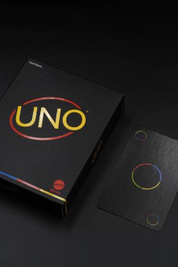 Uno Minimalista black playing card box with color changing cards on the side with black background clipart