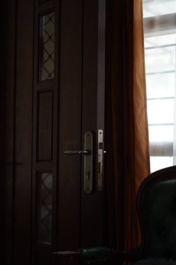 Açık ve sandalyeye yakın bir evin ahşap kapısı.