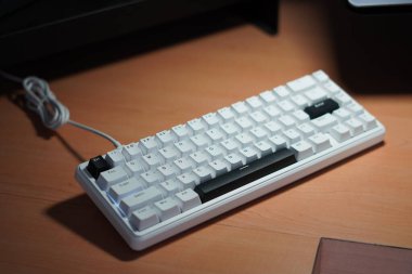 Tahta bir masa üzerinde monokrom (siyah ve beyaz) temalı% 65 mekanik klavye.