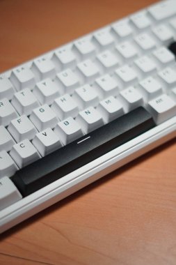 Tahta bir masa üzerinde monokrom (siyah ve beyaz) temalı% 65 mekanik klavye.