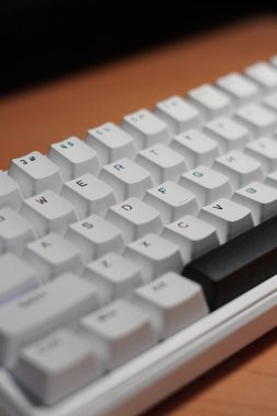 Tahta bir masa üzerinde monokrom (siyah ve beyaz) temalı% 65 mekanik klavye.