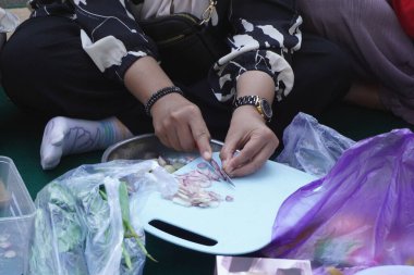 Bir kadının eli gün boyunca kırmızı soğan kesiyor.