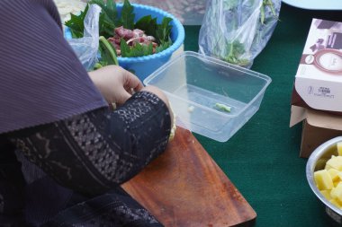 Bir kadının eli bıçak ve kesim tahtası kullanarak beyaz brokoli kesiyor.