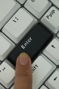 Tek renkli klavyede giriş tuşuna basan bir işaret parmağı