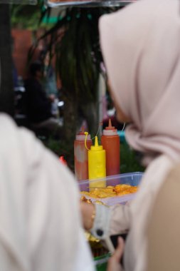 Farklı soslar (ketçap, acı biber sosu ve mayonez) içeren üç şişe.