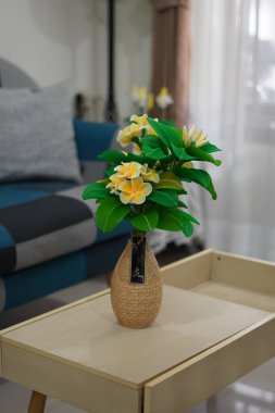 Oda dekorasyonu için eşsiz yuvarlak bir tencerede suni beyaz frangipani çiçekleri.