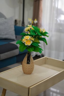 Oda dekorasyonu için eşsiz yuvarlak bir tencerede suni beyaz frangipani çiçekleri.