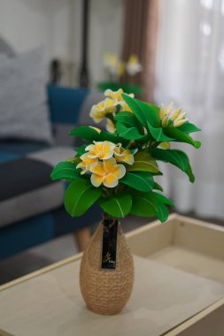 Oda dekorasyonu için eşsiz yuvarlak bir tencerede suni beyaz frangipani çiçekleri.