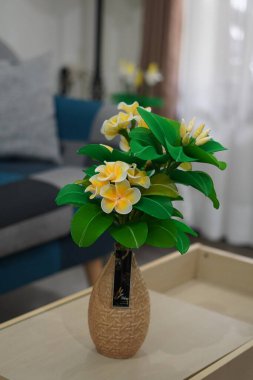 Oda dekorasyonu için eşsiz yuvarlak bir tencerede suni beyaz frangipani çiçekleri.