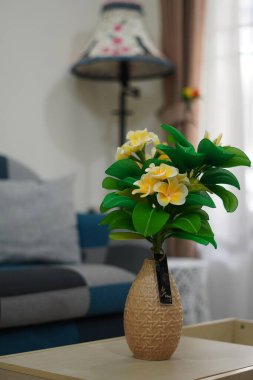 Oda dekorasyonu için eşsiz yuvarlak bir tencerede suni beyaz frangipani çiçekleri.