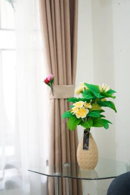 Oda dekorasyonu için eşsiz yuvarlak bir tencerede suni beyaz frangipani çiçekleri.