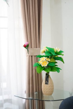 Oda dekorasyonu için eşsiz yuvarlak bir tencerede suni beyaz frangipani çiçekleri.