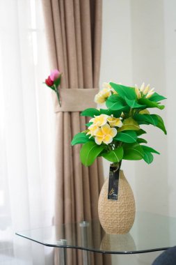 Oda dekorasyonu için eşsiz yuvarlak bir tencerede suni beyaz frangipani çiçekleri.