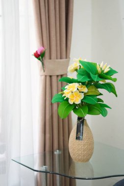 Oda dekorasyonu için eşsiz yuvarlak bir tencerede suni beyaz frangipani çiçekleri.