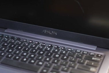 Asus logosu siyah bezel ve klavyeli bir dizüstü bilgisayarın altında yer almaktadır.