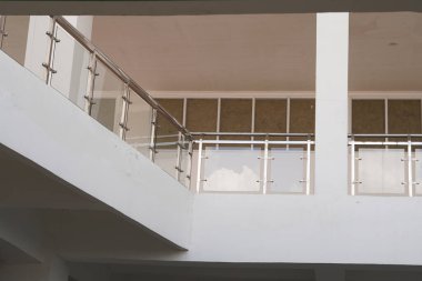 Minimalist çok katlı bir binada cam güvenlik korkuluğu.