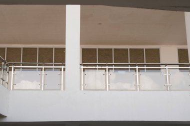 Minimalist çok katlı bir binada cam güvenlik korkuluğu.