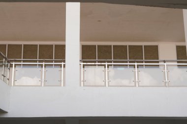 Minimalist çok katlı bir binada cam güvenlik korkuluğu.