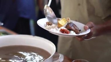 Bir insan öğle yemeği için tabağına açık büfe tabakları koyar.