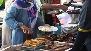 Öğlen büfede soya peyniri, ızgara tavuk ve sebze yiyen biri.